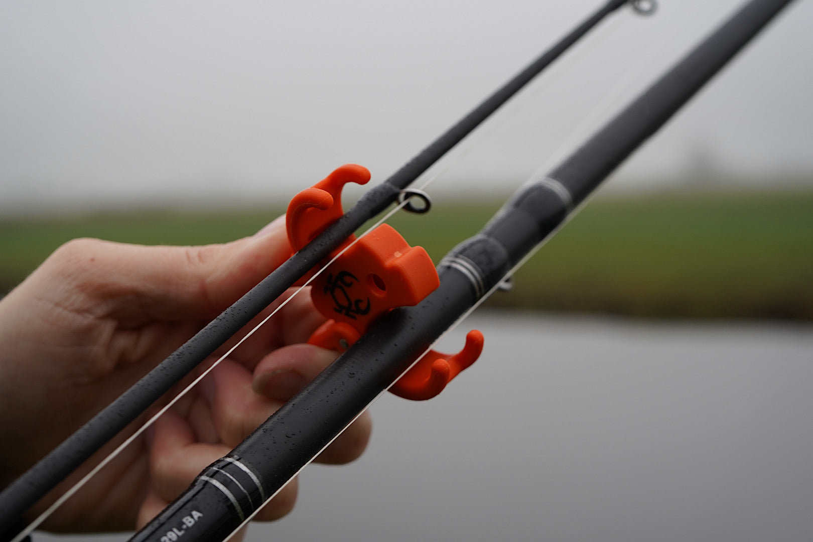 Rod Crab multi-piece fishing rod clamp with spring hinge and hook loop for secure transport and storage