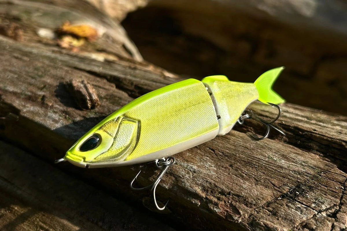 Nays TRN 130 S-34 bright green two-piece swimbait on a log in the sun