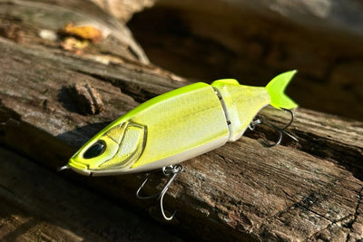Nays TRN 130 S-34 bright green two-piece swimbait on a log in the sun