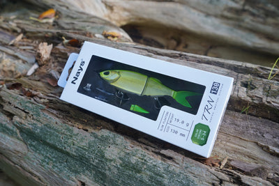 Nays TRN 130 S-34 swimbait in its box on a weathered tree log